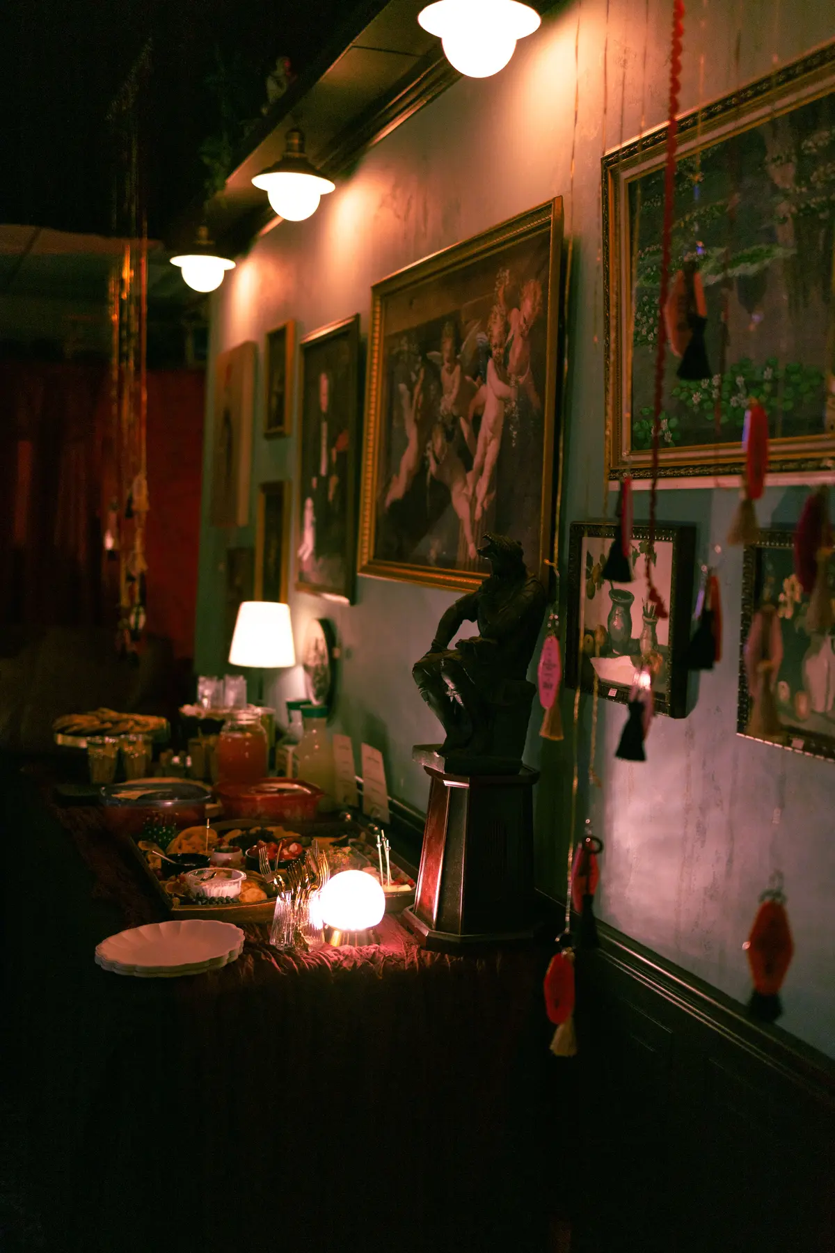 An altar wall with candles, branches and framed art