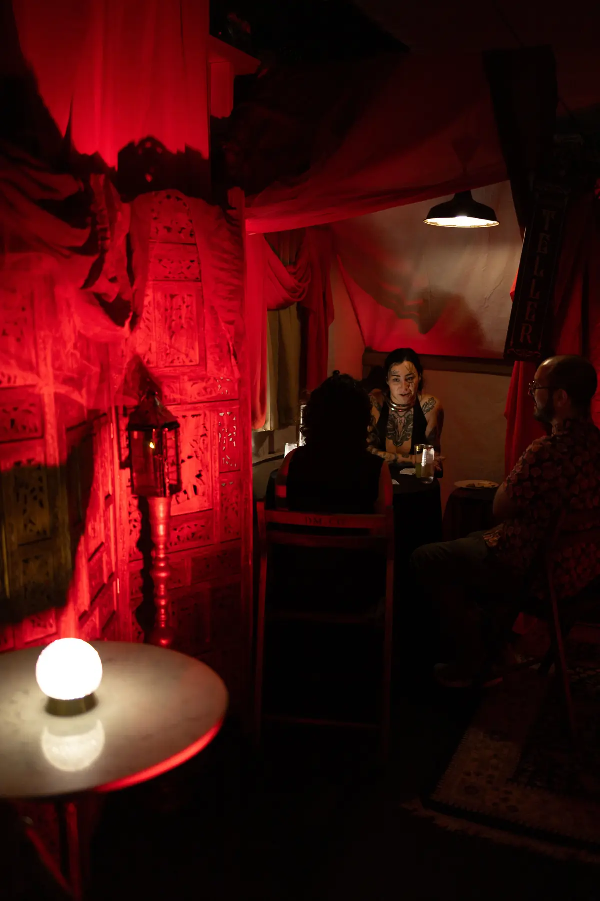 A guest entering a red draped room at The Fool’s Journey