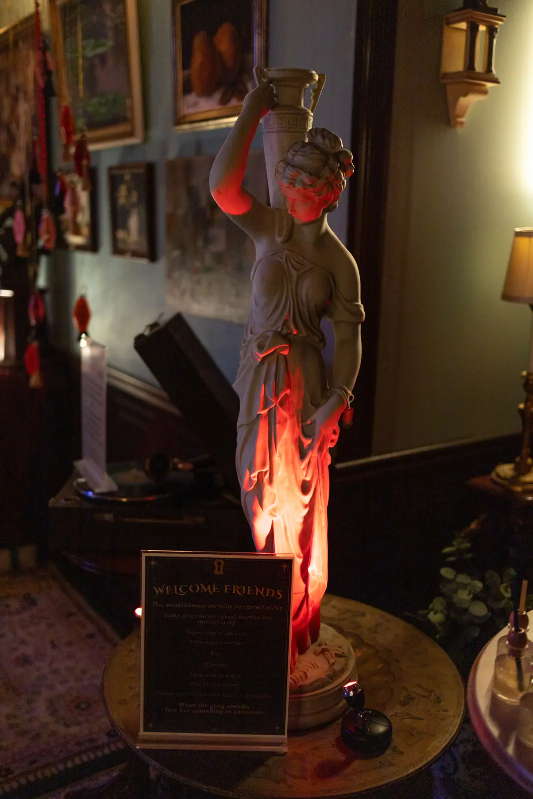 A sculptural figure and antique display lit from below in red