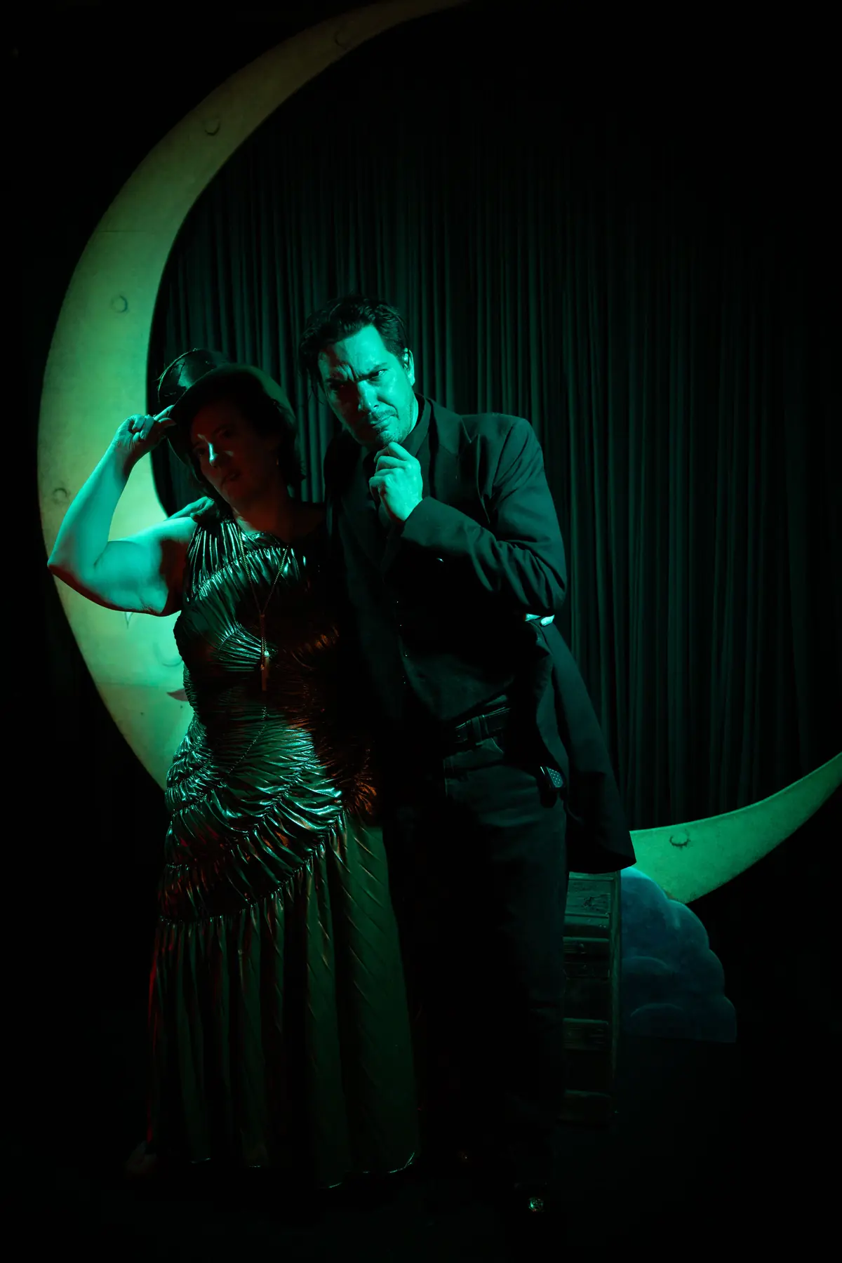 Two guests posing within a glowing crescent moon
