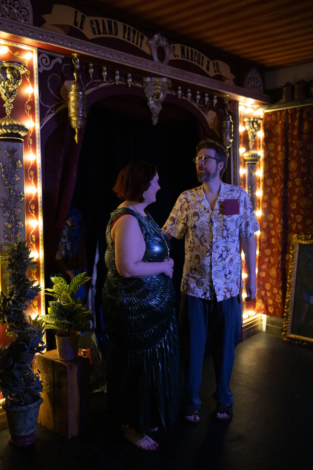 Guests participating in a ritual before a glowing framed mirror