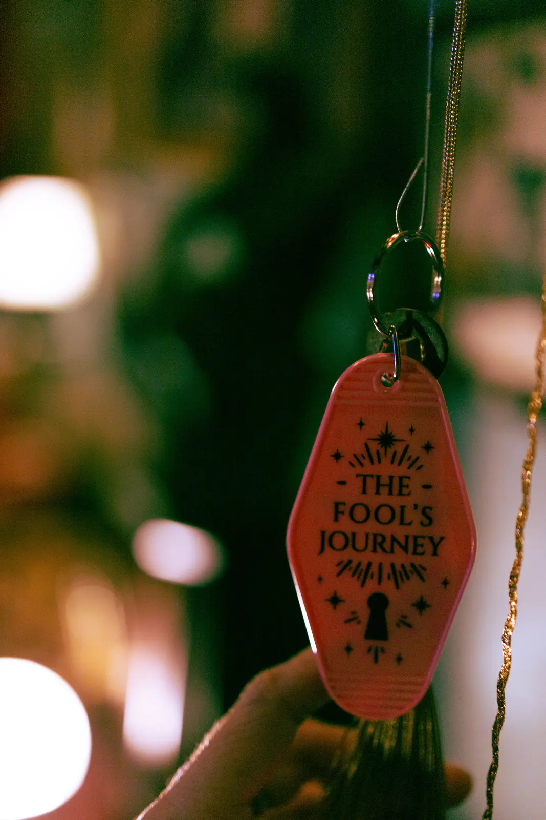 A Fool’s Journey token among warm lights