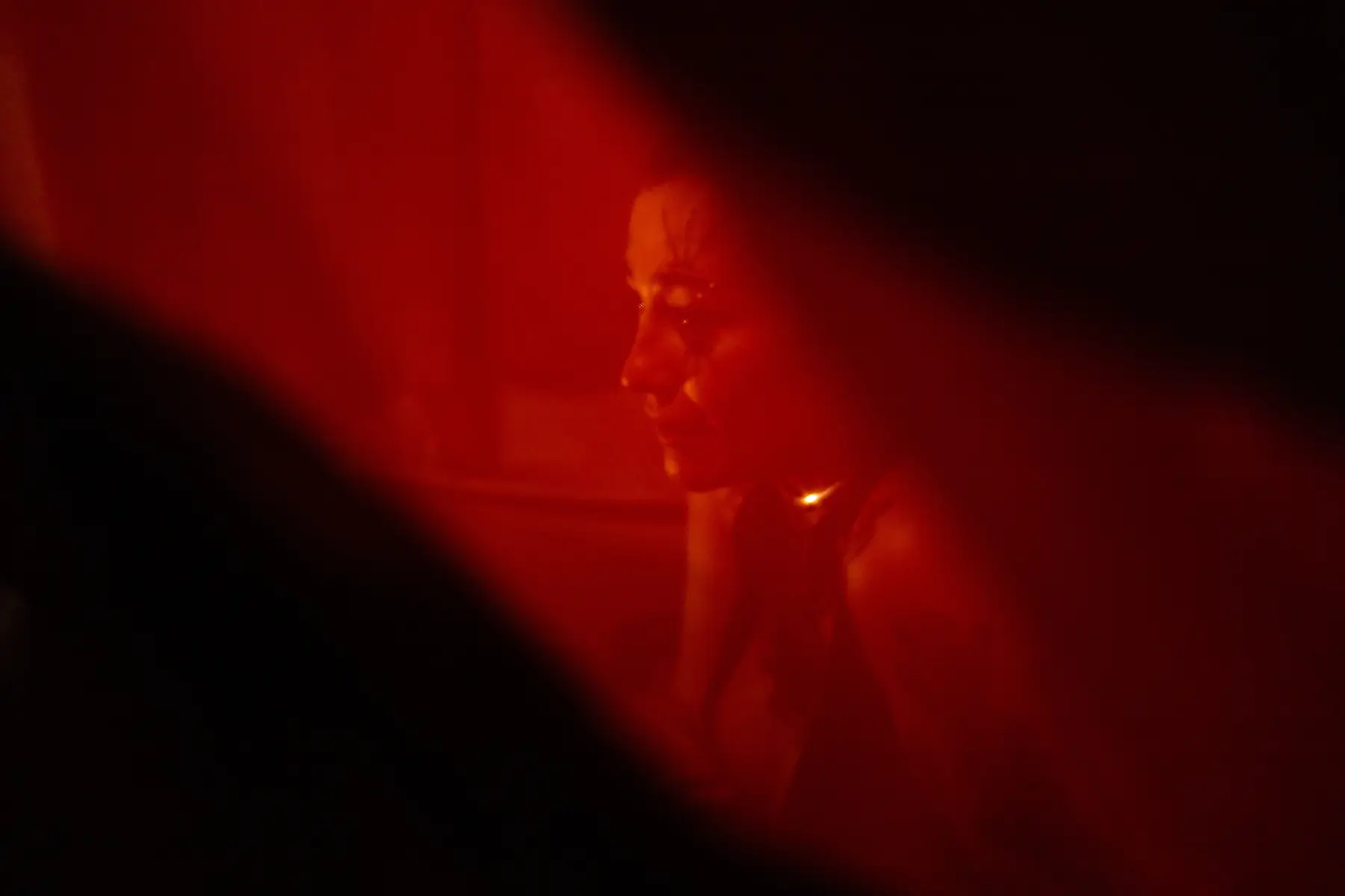 A figure seen through a translucent red veil